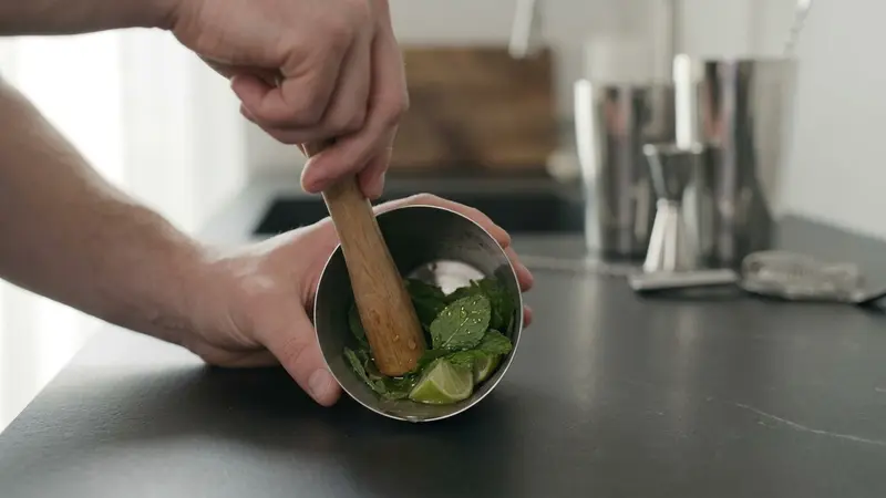 Muddle mint with lime and syrup